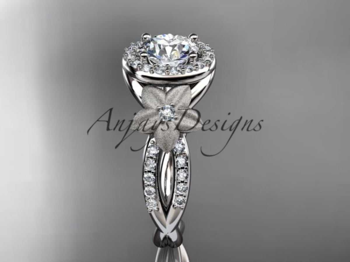 White gold diamond engagement ring, style ADLR127. Front view showcasing a round center diamond diamond halo and a matte-finish flower accent on a split diamond band.