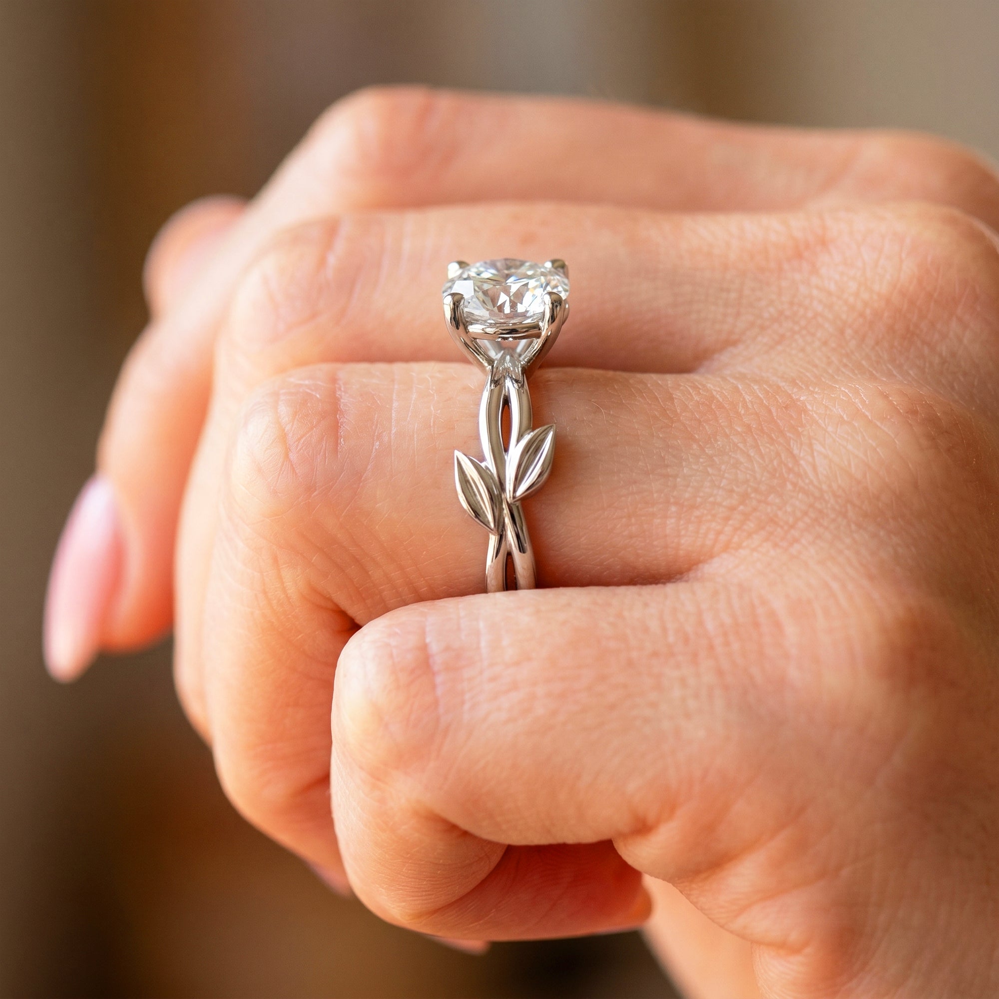 Nature inspired leaf engagement ring shown on hand in 14k white gold