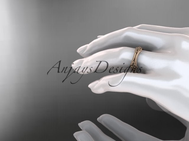 14K rose gold matte Celtic wedding band displayed on a mannequin hand, viewed from the side.