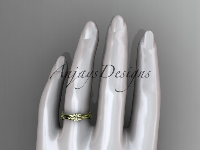 1. 14K yellow gold Celtic trinity knot wedding band shown from above on a mannequin hand.