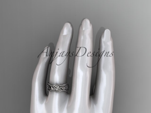 Platinum Celtic wedding band, style CT7508P, worn on the ring finger of a white mannequin hand. Top-down view showing the realistic finger coverage of the patterned openwork band.