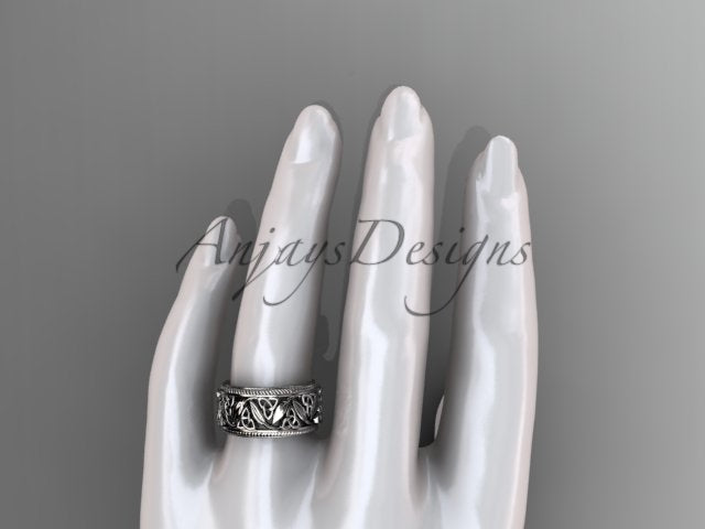 Platinum wide Celtic wedding band, style CT7508P, worn on the ring finger of a white mannequin hand. Top-down view showcasing the realistic scale and striking details of the openwork pattern.